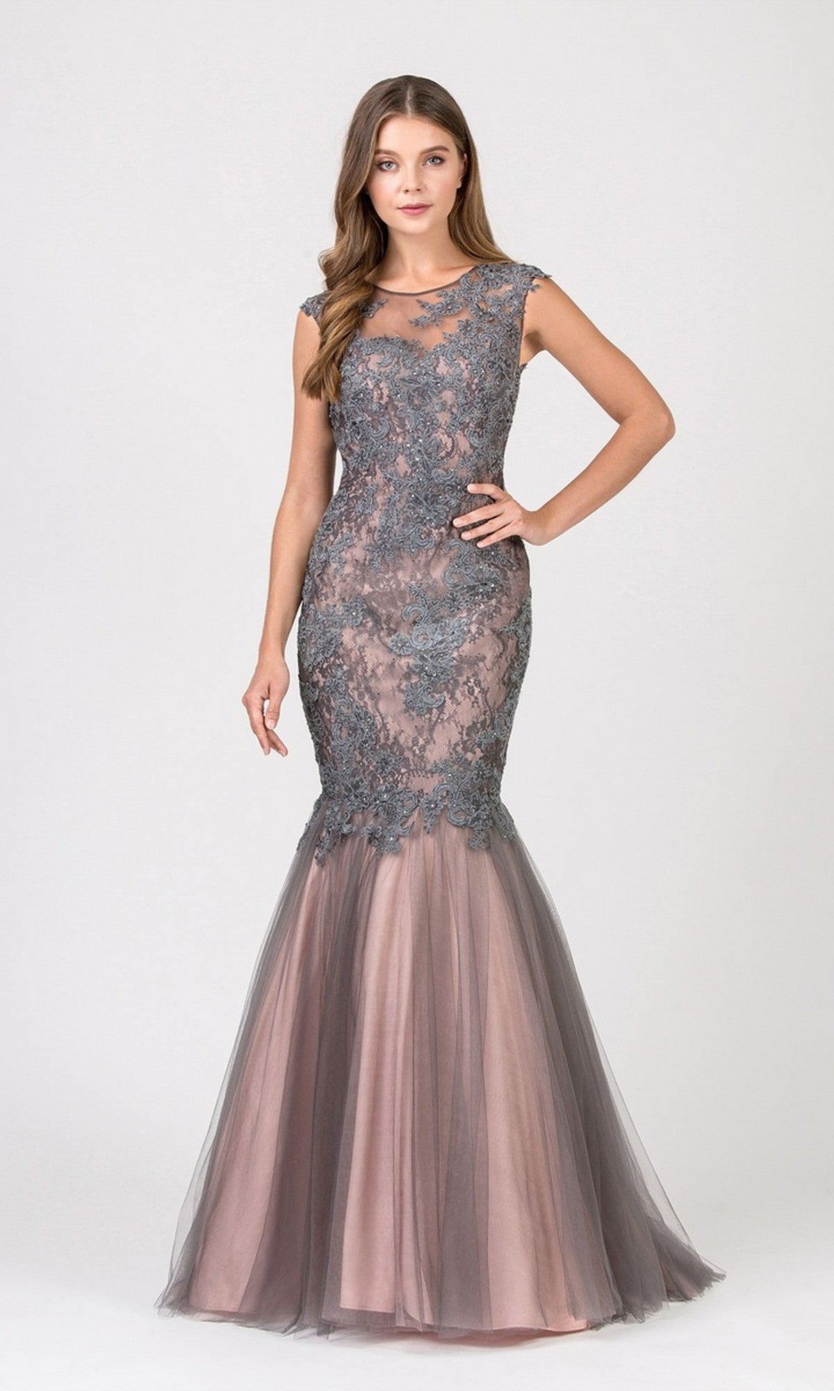 A woman stands against a plain light background wearing the Long Prom Dress: Eureka 8510 in Charcoal/Blush, featuring a sleeveless bodice, floor-length lace mermaid silhouette, gray overlay, and sheer tulle skirt.